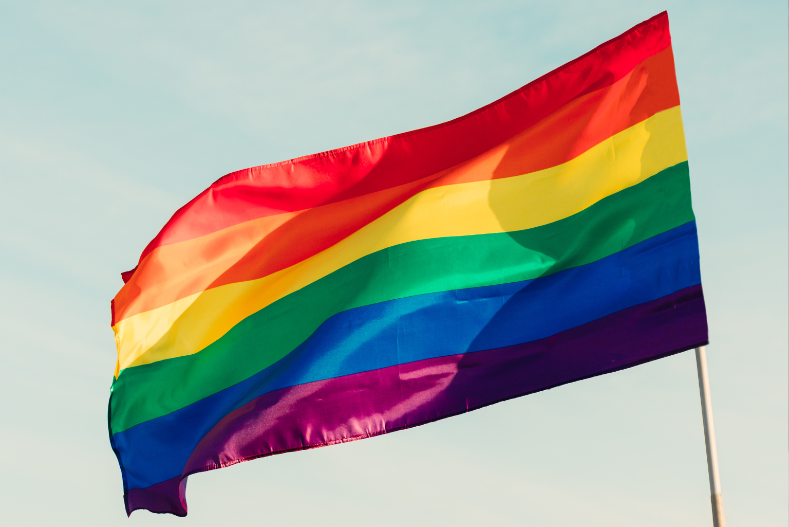 Bandeira LGBTQIA+ representando a comunidade queer, simbolizando a união com a medicina reprodutiva como aliada.